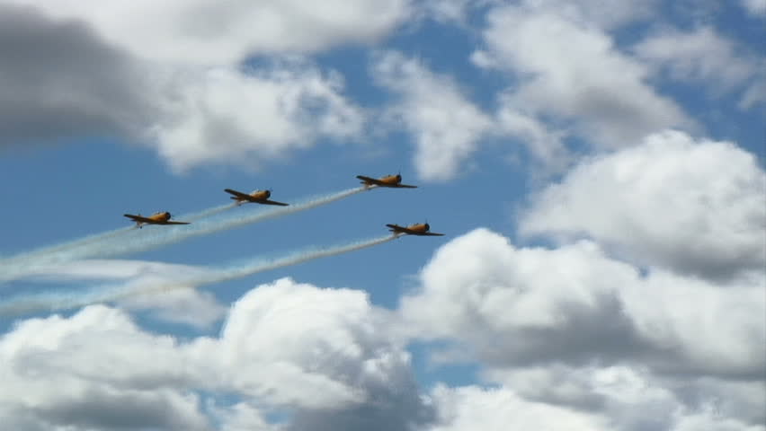 Formation of RCAF Harvards fly in front a formation of USAF T-6 Texans.