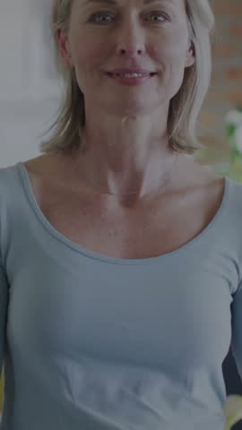 Animation of dna strand over portrait of caucasian woman at home. Global science, lifestyle and digital interface concept digitally generated video.
