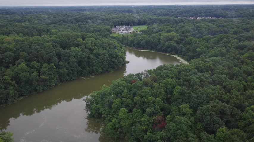 Drone aerial of big house mansion home and upper class income residential living along big walnut creek water river way outside Columbus and Galena, OH in Ohio landscape with trees, woods, and forest