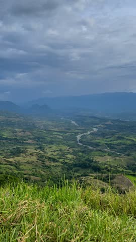 Travel Photographer Taking Pictures of Scenic Mountain Valley Landscape with River Under Dramatic Cloudy Sky