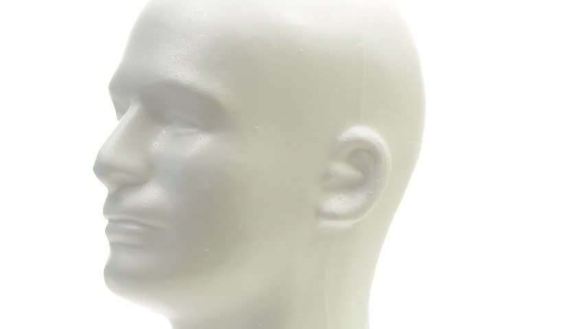 Rotating mannequin head on white background.