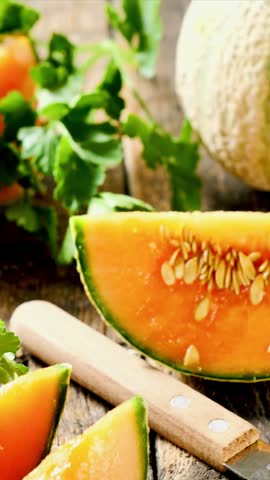 Fresh melon slices with prosciutto ham and arugula on wooden board, vertical footage	