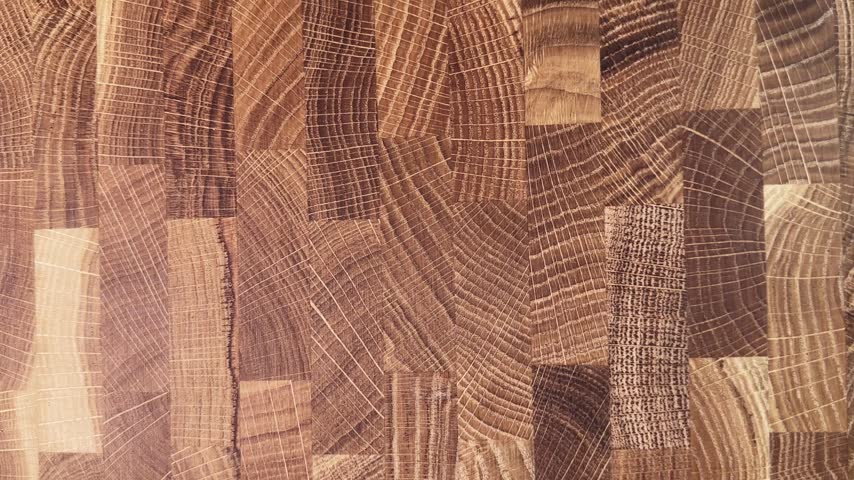 Demonstration of the work surface of oak end grain cutting board made of glued natural oak pieces cut cross-sectionally close-up 
