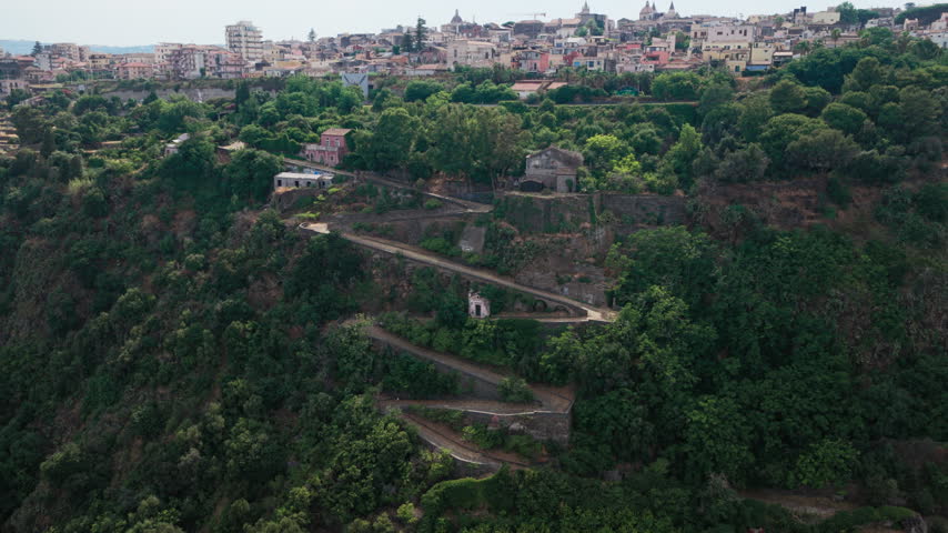 Epic aerial of Chiazzette trail to Santa Maria la Scala, a fishing village surrounded by volcanic cliffs near Mount Etna in Acireale, Catania, Sicily, Italy, a popular destination on the Ionian coast.