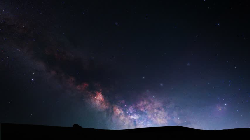 Night sky over hill bright,  colorful milky way galaxy. Space, time lapse.