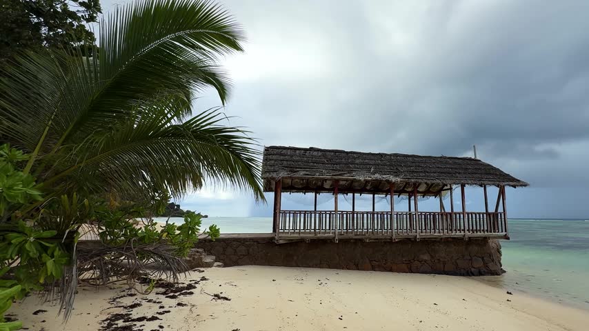 Beach hut by the water on a cloudy day during the afternoon with trees in the background