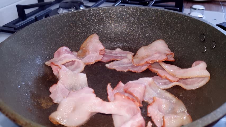 Bacon pieces frying in a pan. Illustration for food blogs and projects. Traditional breakfast. Appetizing meat in a frying pan.