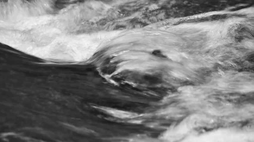 Black and White Close Up Shot of Fast Rushing Water Stream Flowing Over Rocks