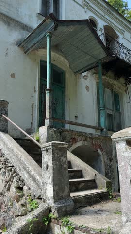Vintage stone porch with old stairs and canopy at entrance of abandoned historical mansion