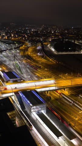 night illuminated zurich city industrial area traffic street bridge railway train sation aerial panorama 4k vertical timelapse switzerland