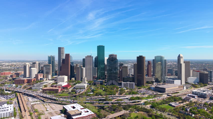 High-angle view of Houston skyline with commercial buildings and expressways. City center reflects growth, business and innovation.