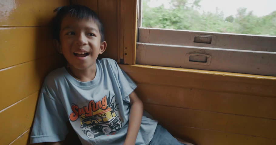 Little asian boy enjoy travel in local old train backpacker kids Thailand
