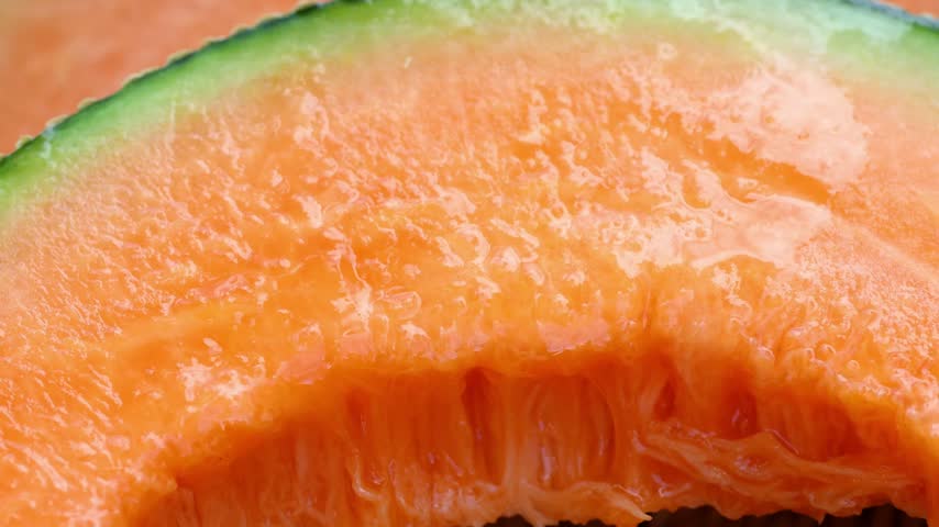 Fresh cantaloupe melon sliced on wooden
