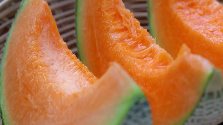 Fresh cantaloupe melon sliced on wooden
