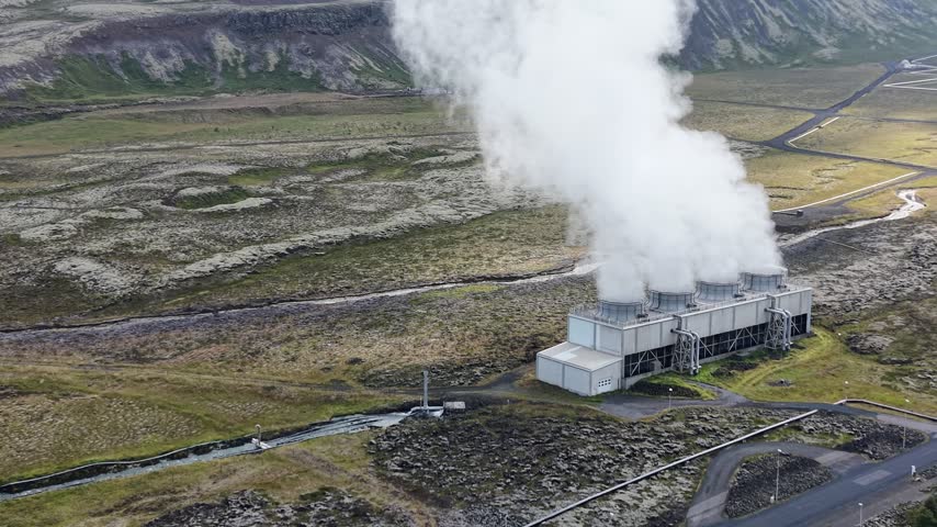 Aerial view of Nesjavellir Geothermal Power Station with steam rising from cooling towers over the volcanic landscape in Selfoss, Grimsnes- og Grafning, Iceland.