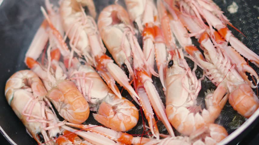 Top View of Fresh Langoustines Cooking in Hot Pan with Butter. Shellfish Seafood being Cooked Outdoors in Slow Motion. Norway Lobster.