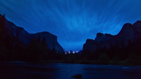 Night to Day TIme Lapse of Yosemite Valley in Yosemite National Park on a cloudy morning. Clouds covering the sky with sunrise color shinning on the clouds at the sunrise moment.
