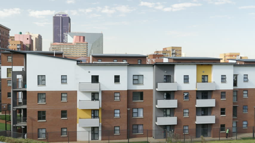 Brickfields Housing Estate apartment blocks stand in front of the Johannesburg CBD skyline on a clear morning.