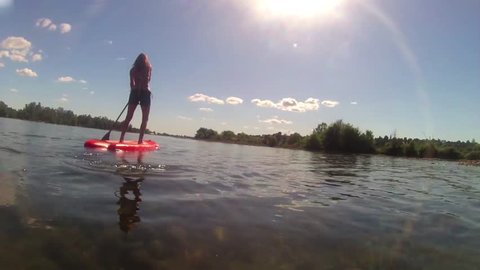 SEXY GIRL WOMAN SUP STAND UP PADDLE BOARDING COOL TRACKING SHOT ON BEAUTIFUL SUNNY LAKE. 30 SECOND COMMERCIAL STOCK FOOTAGE CLIP HD 1080 HIGH DEFINITION 1920x1080 MODEL RELEASE ATTACHED