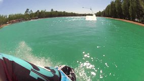 SLOW MOTION OF WAKEBOARDER WAKEBOARDING COOL POINT OF VIEW SHOT POV DOING TRICKS AND STUNTS AT WAKEBOARD PARK ON BEAUTIFUL HOT SUNNY DAY ON THE CABLE PULL LAKE HD 1920X1080 HIGH DEFINITION 1080