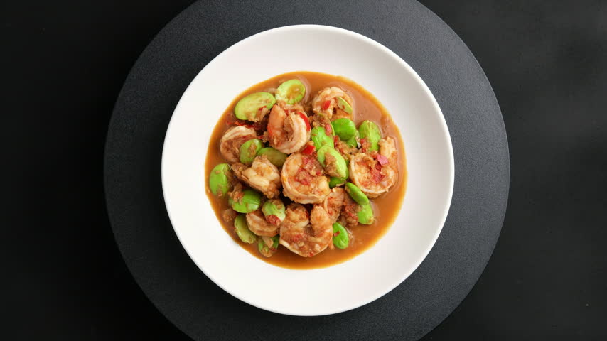 Stir fried Stink Beans(Bitter Beans) with Shrimp Paste and Fresh Prawns in white plate.Top view.