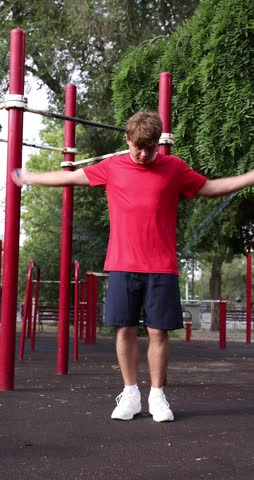 Teenage boy exercising with jumping rope at outdoor sports ground
