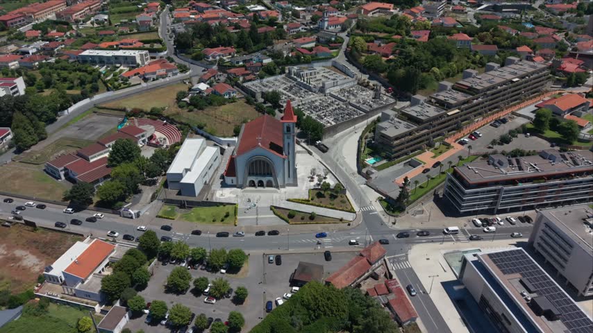 Aerial - Main church of Vizela with cemetery apartment blocks and busy crossroads Braga Portugal