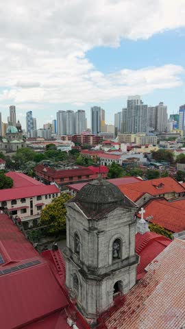 Aerial drone view of San Agustin Church in Intramuros with the modern Manila skyline in the background. Historic UNESCO World Heritage landmark and colonial architecture.