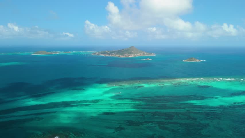 High altitude aerial shows Petite Martinique, Petit Saint Vincent and Petite Dominique scattered across turquoise Grenadine waters and coral reefs