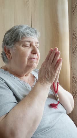 Senior Woman Praying with Hands Together at Home in Quiet Reflection 4K Vertical Video