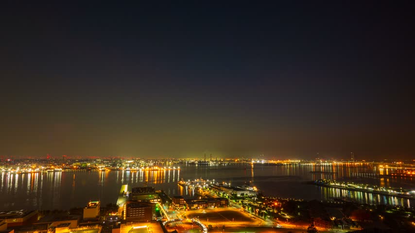 Sunrise time lapse of Yokohama port and Minatomirai cityscape zooming in.

