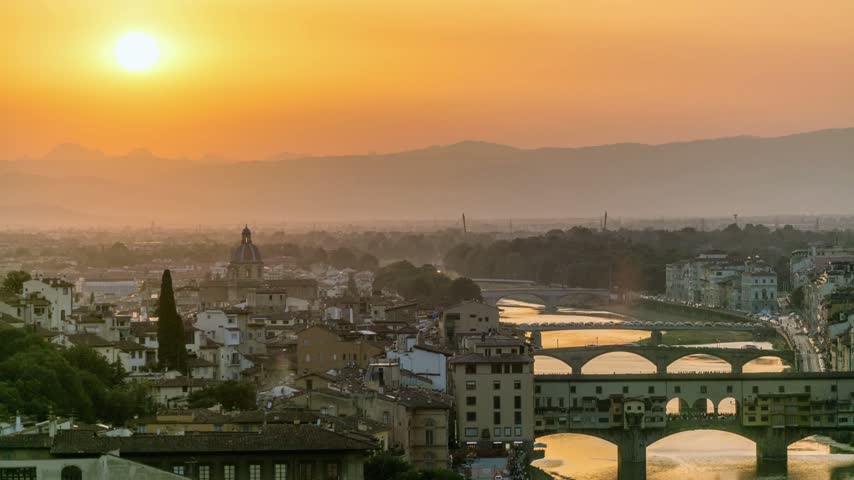 Sunset hyperlapse and time lapse video of bridges over the Arno River in Florence, Italy, showing historic buildings, warm evening light, and the riverside cityscape. A scenic view of Florence’s historic urban landscape.