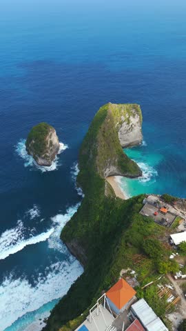 A Dramatic Limestone Cliff Shaped Like Tyrannosaurus Rex Overlooks Kelingking Beach On Nusa Penida, Bali, Indonesia. Vertical, Aerial Shot
