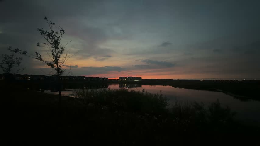 Apartment building next to a pond in the evening sunset extreme wide