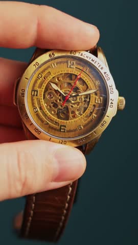 A detailed view of a classic analog timepiece featuring a skeleton dial, intricate mechanical movement, and a leather strap