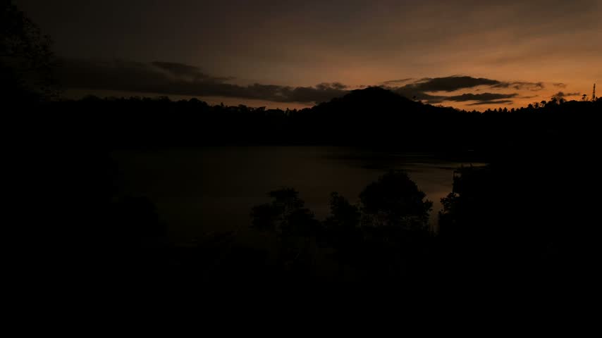 Sunrise timelapse over Puerto Galera bay with silhouetted hills and calm tropical water.