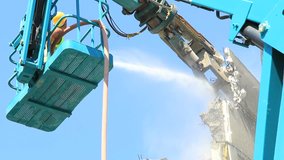 A demolition crane in action with a building. Find similar clips in our portfolio.