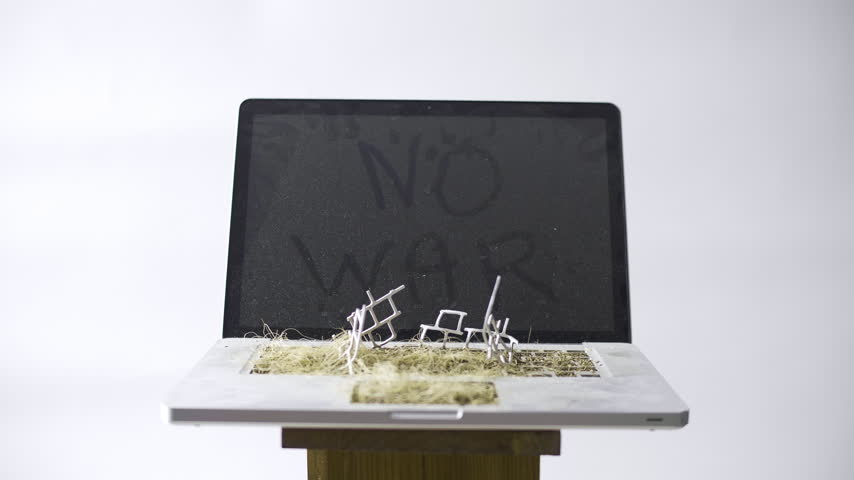 Post apocalyptic laptop reclaimed by nature with dried grass and No War message