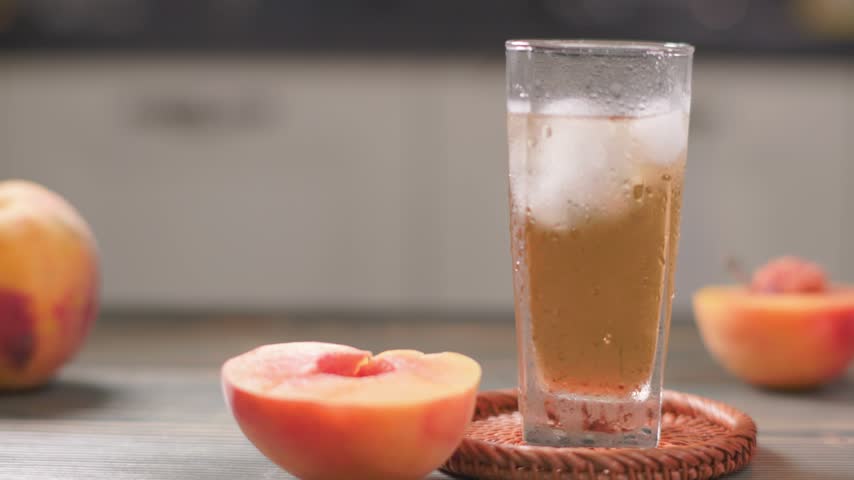 Finished Peach Extract Juice With Ice Cubes In Glass Slow Slider Shot
Cinematic slow slider shot of a finished peach extract juice drink in a glass filled with ice cubes, surrounded by fresh peaches. The refreshing golden beverage, transparent ice, chilled glass, and shallow depth of field create an attractive premium food and beverage scene. Ideal for summer drinks, fruit beverages, commercial advertising, lifestyle, restaurant, and food promotional projects.