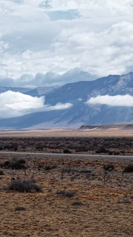 Scenic landscape of Patagonia Argentina with a road stretching through the vast steppe towards the Andes mountains under a cloudy sky