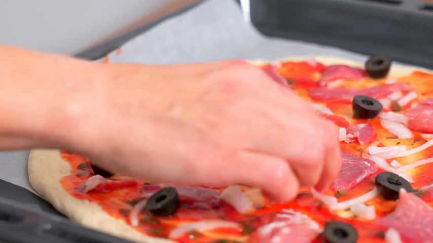Beautiful kitchen video with making of homemade round 
pizza with vegetables, meat, olive, tomato, cheese.
Appetizing tasty dish.