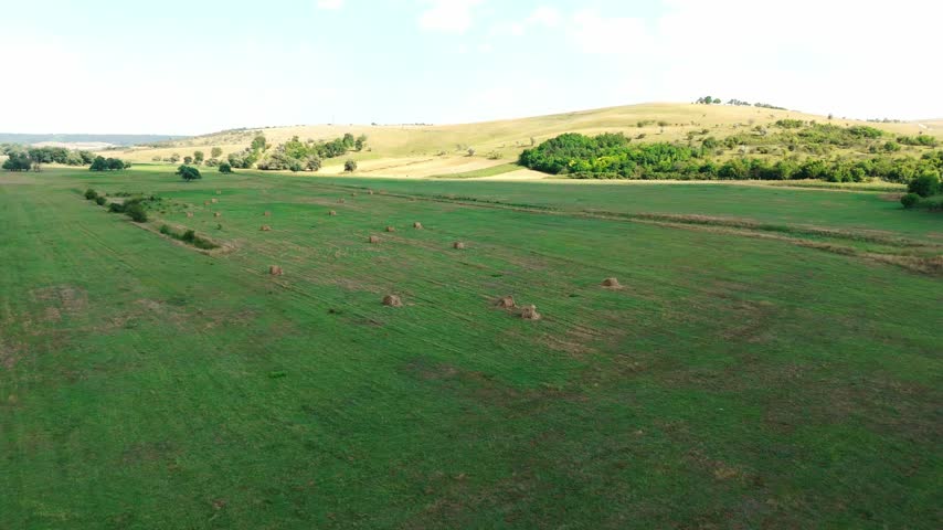 Aerial View of Rolling Hills with Hay Bales