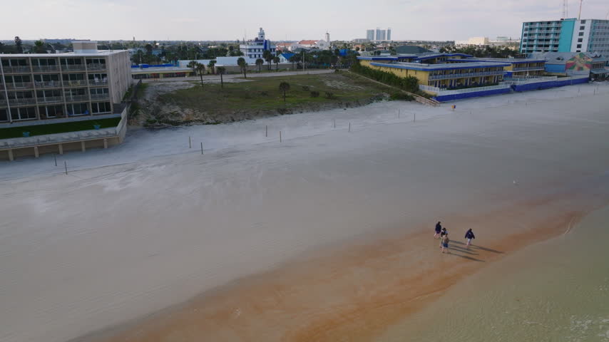 Aerial drone view of beachfront hotels along Daytona Beach, Florida, with Atlantic Ocean waves, sandy shoreline, and coastal cityscape, filmed in ProRes 422HQ