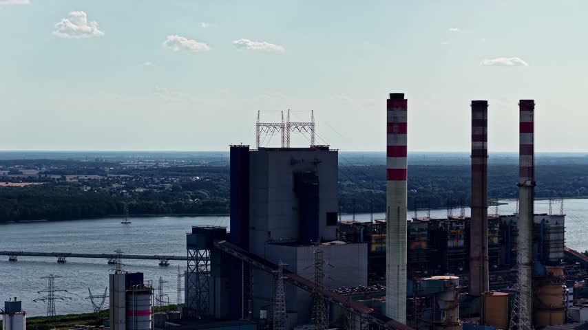 Aerial view of the ZE PAK S.A. Patnow Power Plant with its tall chimneys and industrial structures situated near a river in Konin, Wielkopolskie, Poland.