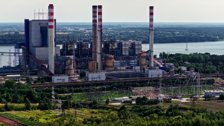 Aerial view of the industrial Patnow Power Station with tall chimneys and cooling towers situated near a river in Konin, Wojewodztwo wielkopolskie, Poland.