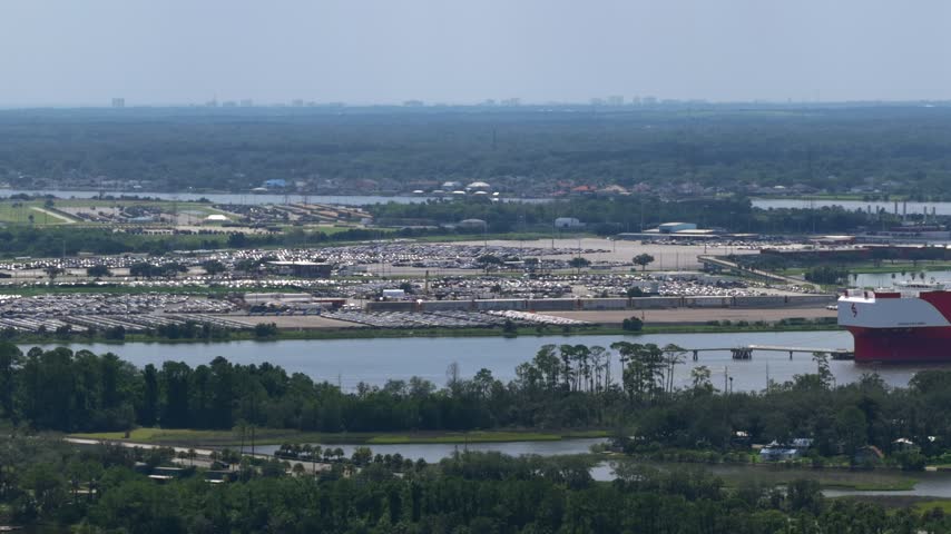 Aerial view of JAXPORT Blount Island Marine Terminal with rows of parked vehicles and shipping infrastructure in Jacksonville, Florida, United States.