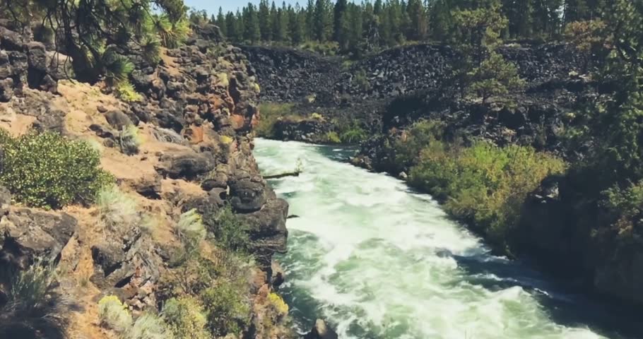 Scenic video footage of powerful river rapids rushing over rugged rocks in a natural wilderness landscape. The fast-flowing water creates dynamic movement and energetic scenery, ideal for nature, adventure, whitewater, outdoor recreation, ecology, travel, and environmental concepts.