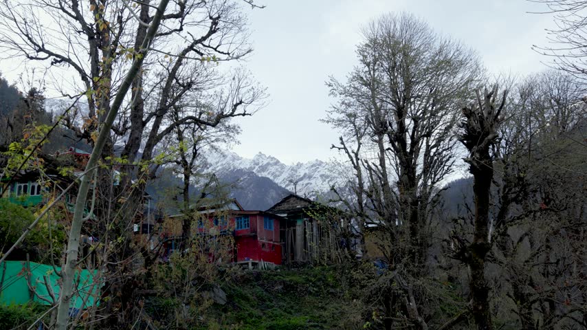 Traditional Himalayan Village Houses with Snow Covered Mountains in the Background