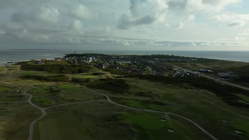 Drone flight over the rooftops of Hornum on Sylt with the church, the harbour, the beach and the southern tip of the island at the North Sea