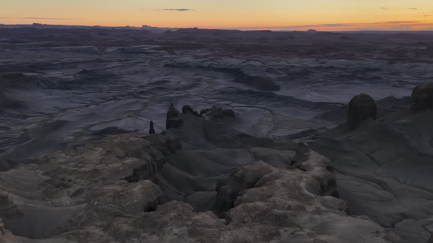 Aerial view of the rugged desert terrain and rock formations at Moonscape Overlook during golden hour in Hanksville, Utah, United States.